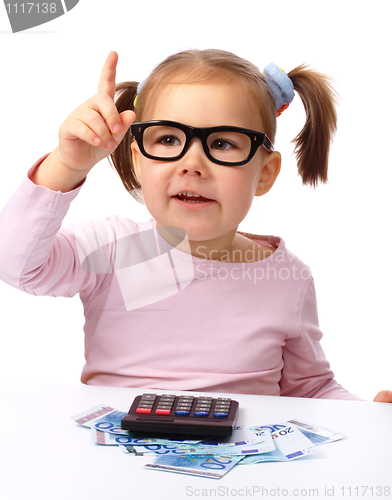 Image of Little girl plays with money