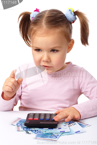 Image of Little girl plays with money