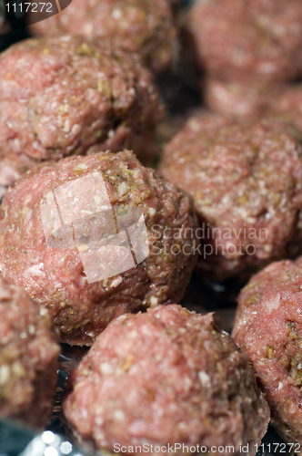 Image of raw meatball in foil wrapped cooking dish