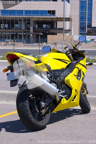 Image of Yellow Motorcycle parked by the Construction