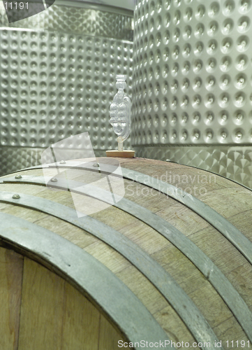 Image of Wine Barrel and Vats - A modern winery cellar showing traditional wooden barrels and modern steel vats.