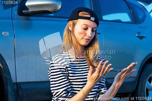 Image of Young Blond Woman With Her Broken Car