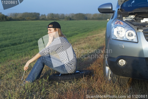 Image of Young Blond Woman With Her Broken Car