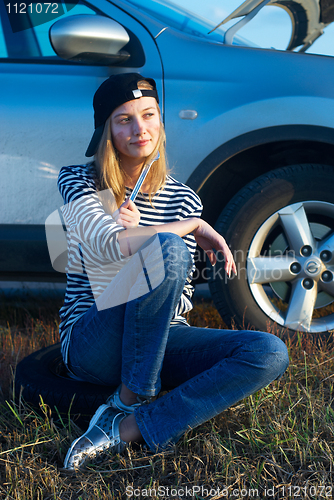 Image of Young Blond Woman With Her Broken Car