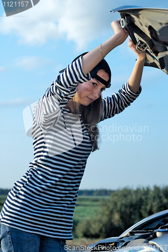 Image of Young Blond Woman With Her Broken Car