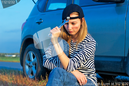 Image of Young Blond Woman With Her Broken Car