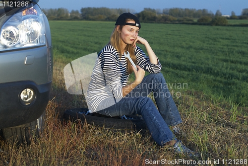 Image of Young Blond Woman With Her Broken Car