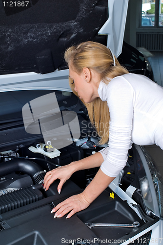 Image of Young woman at broken car