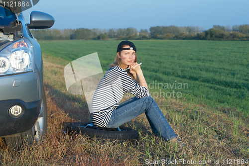 Image of Young Blond Woman With Her Broken Car