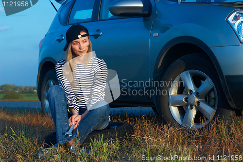 Image of Young Blond Woman With Her Broken Car