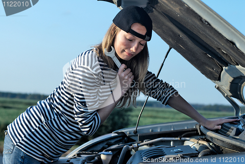 Image of Young Blond Woman With Her Broken Car