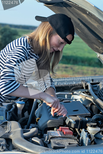 Image of Young Blond Woman With Her Broken Car