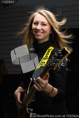 Image of Woman playing on guitar on stage