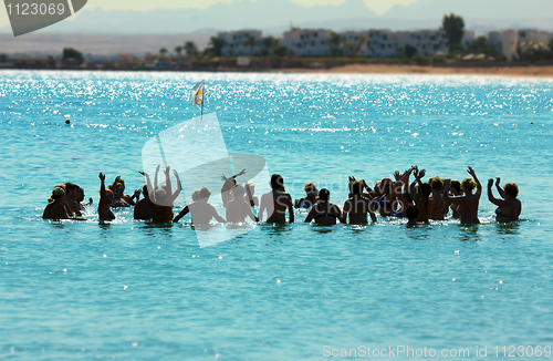 Image of happy people do aerobics in sea