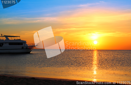 Image of ship at anchor and sunrise over sea