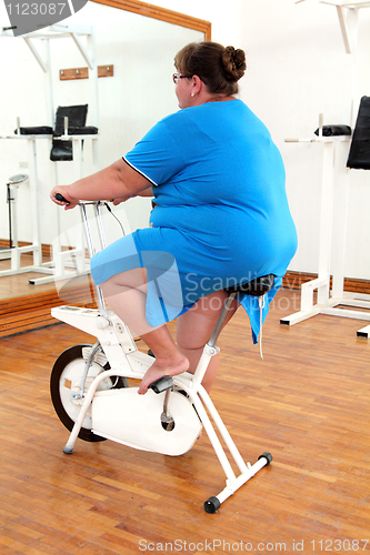 Image of overweight woman exercising on bike