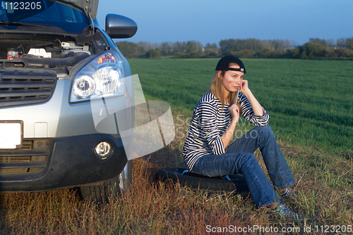 Image of Young Blond Woman With Her Broken Car