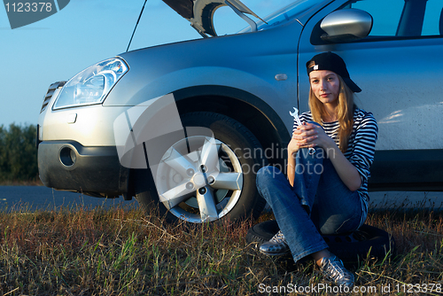 Image of Young Blond Woman With Her Broken Car