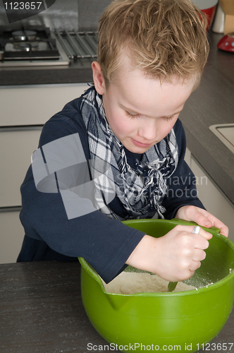 Image of Boy making the dough for the cakes