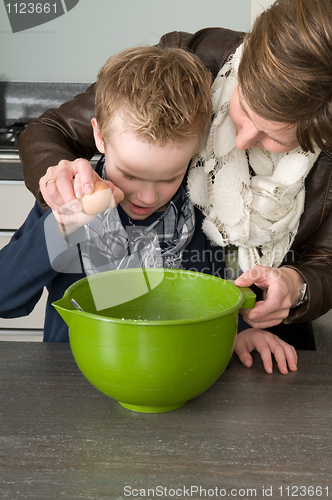 Image of Boy and mother making the dough for the cakes