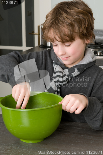 Image of Boy making the dough for the cakes