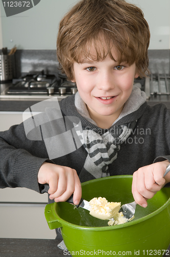 Image of Boy making the dough for the cakes