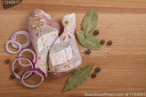 Image of raw chicken meat with herbs, onions and peppers