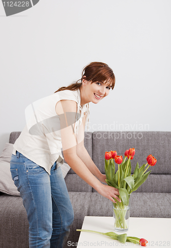 Image of Woman at home holding flowers