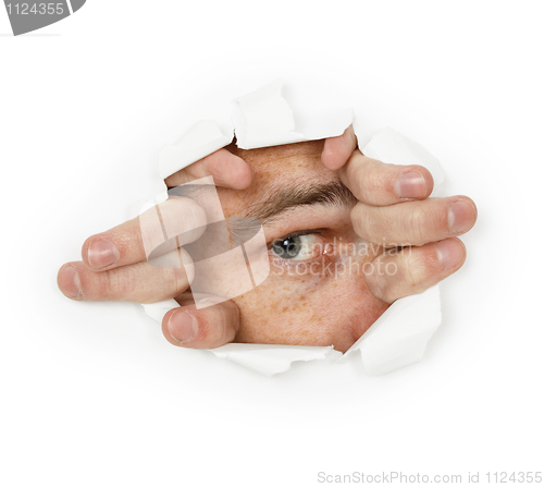 Image of Man looks through a hole in paper