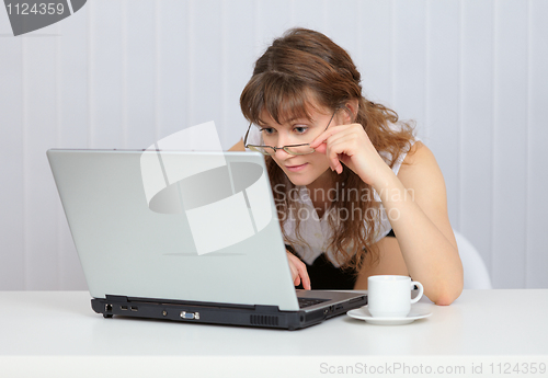 Image of Young girl with glasses working in Internet