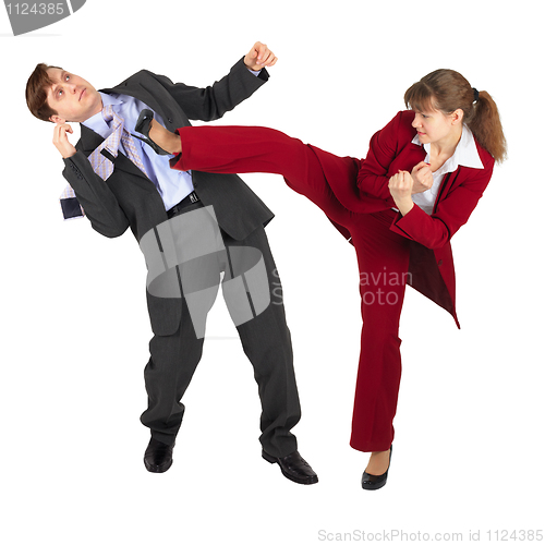 Image of Young woman kicks man in business suit