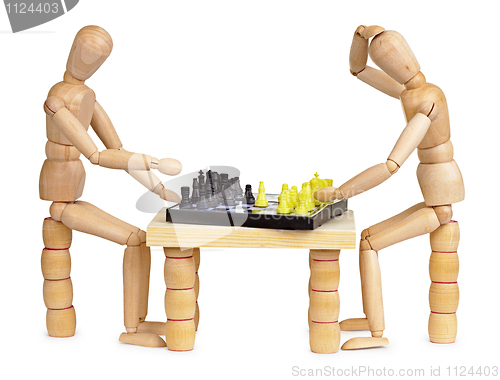 Image of Two silly wooden men play chess