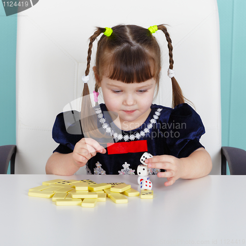 Image of Little girl playing with toys, sitting at table