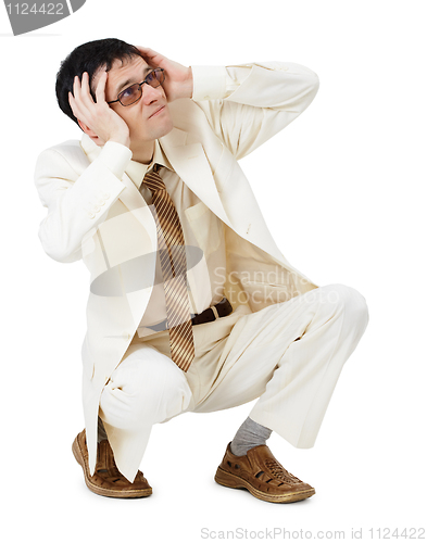 Image of Scared young man in white suit sits