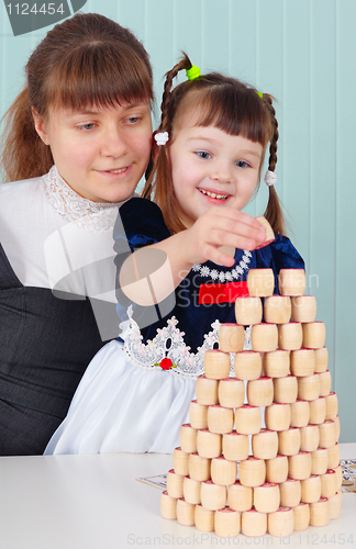 Image of Mom and daughter play - to build a tower