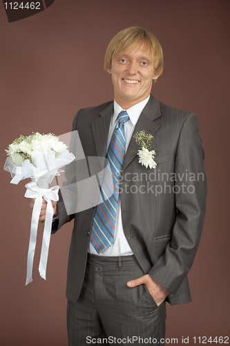 Image of Happily smiling groom with bunch