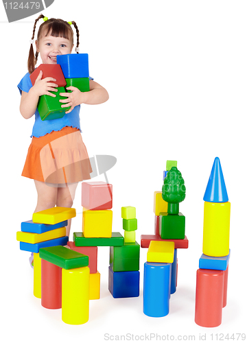 Image of Happy child builds a castle out of blocks