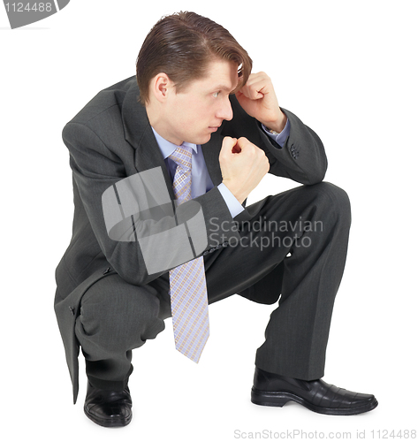 Image of Businessman sitting in defensive pose
