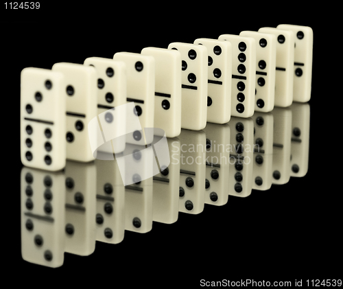 Image of Dominoes ranked on black background with reflection