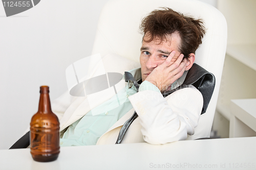 Image of Guy is suffering from hangover because beer is gone