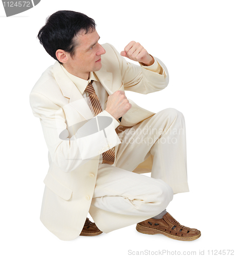 Image of Businessman sitting in defensive posture