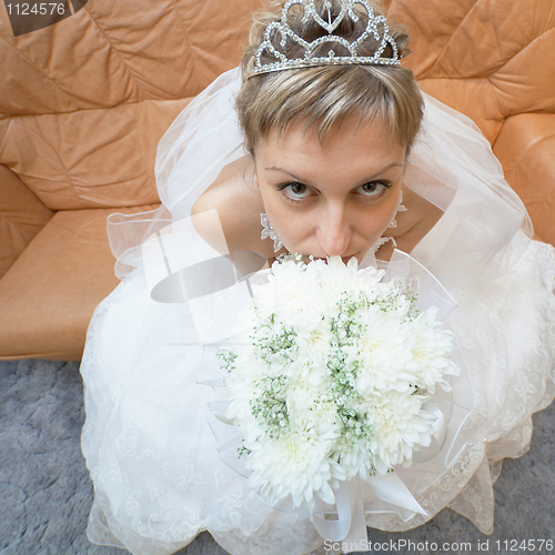 Image of Amusing bride sits on sofa with bouquet - top view