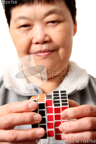 Image of senior chinese woman playing  rubik cube