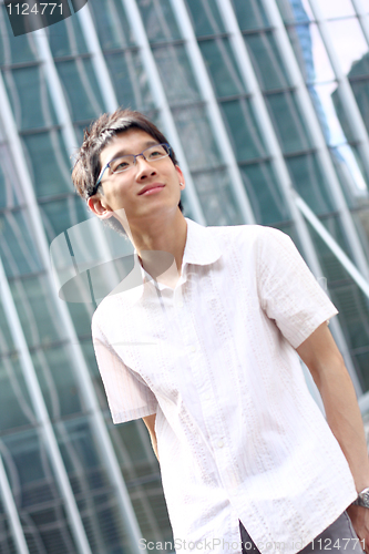 Image of Young businessman looking to good future on modern building back