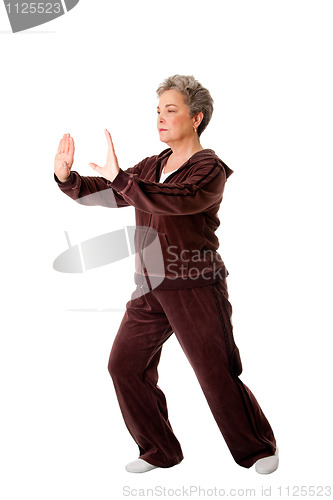 Image of Senior woman doing Tai Chi Yoga exercise