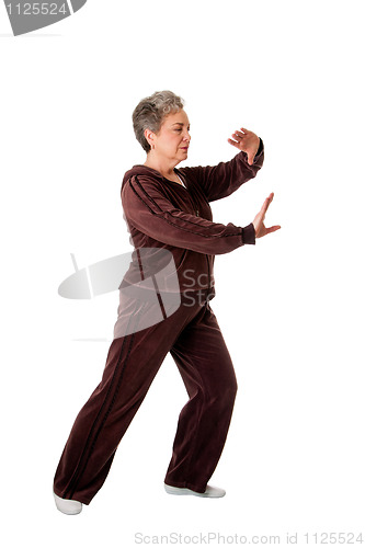 Image of Senior woman doing Tai Chi Yoga exercise