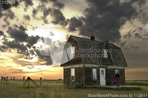 Image of Person entering an old house.