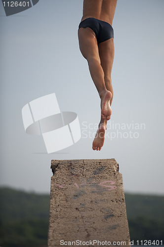 Image of Man jumping from diving platform