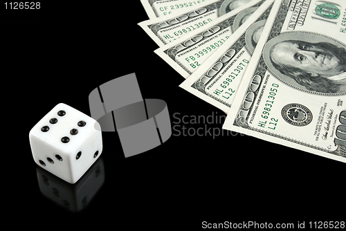 Image of White dice and money on black background