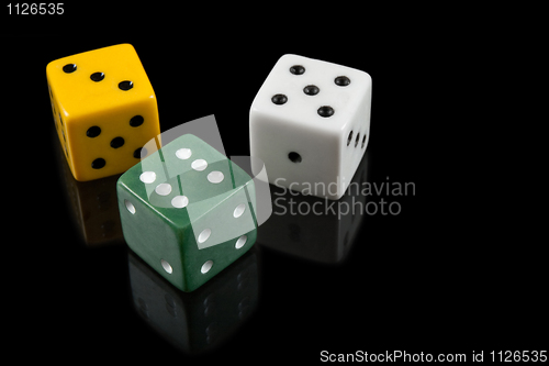 Image of Green, yellow and white dices on black background